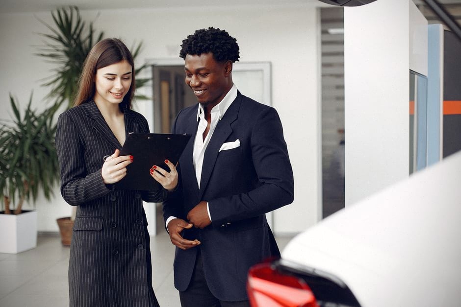 Acheteurs comparant des voitures électriques dans une concession américaine moderne