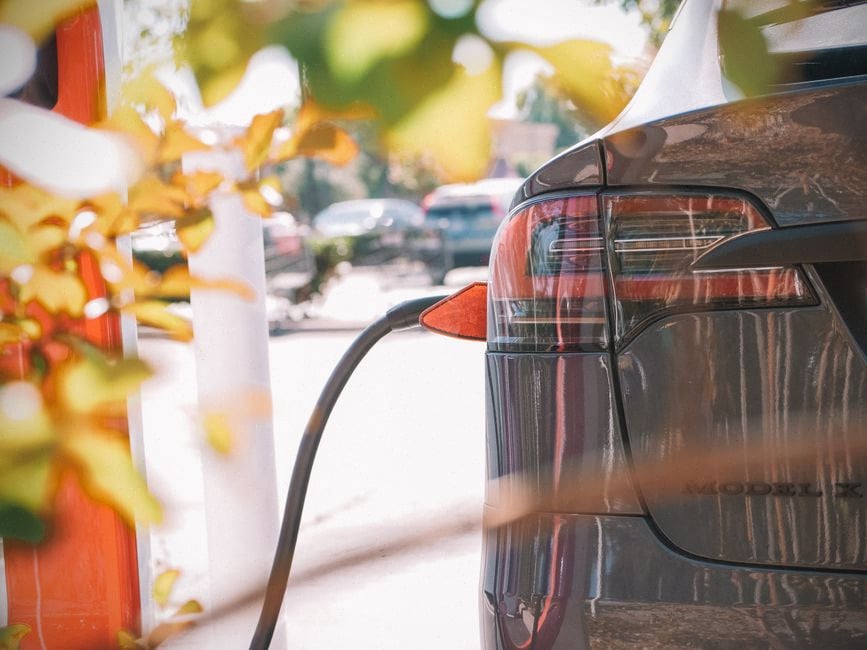 Voiture électrique protégée du soleil sous ombrière de recharge