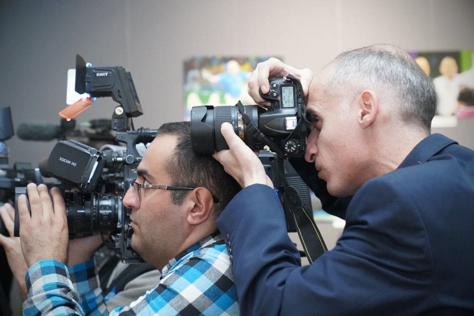 Journalistes vérifiant une image synthétique dans une rédaction moderne