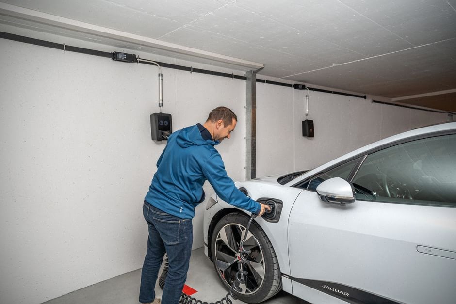 Recharge à domicile d’une voiture électrique devant une maison contemporaine