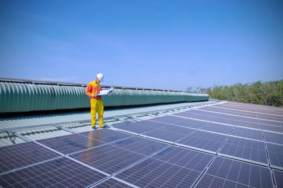 Technicien contrôlant une ferme photovoltaïque raccordée à une plateforme centrale
