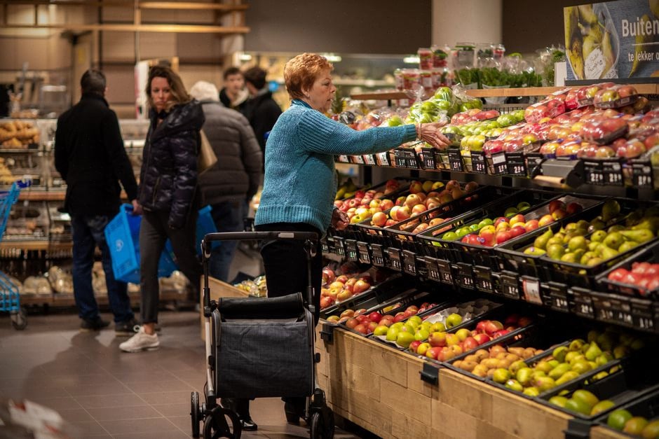 Consommateur comparant les prix alimentaires dans un supermarché luxembourgeois