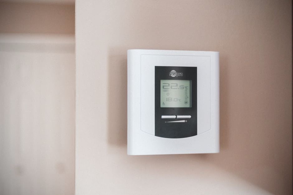 Locataire belge réglant son thermostat face aux prix énergétiques