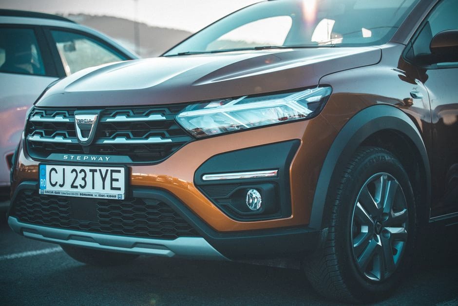 Dacia Spring électrique abordable examinée devant une concession moderne