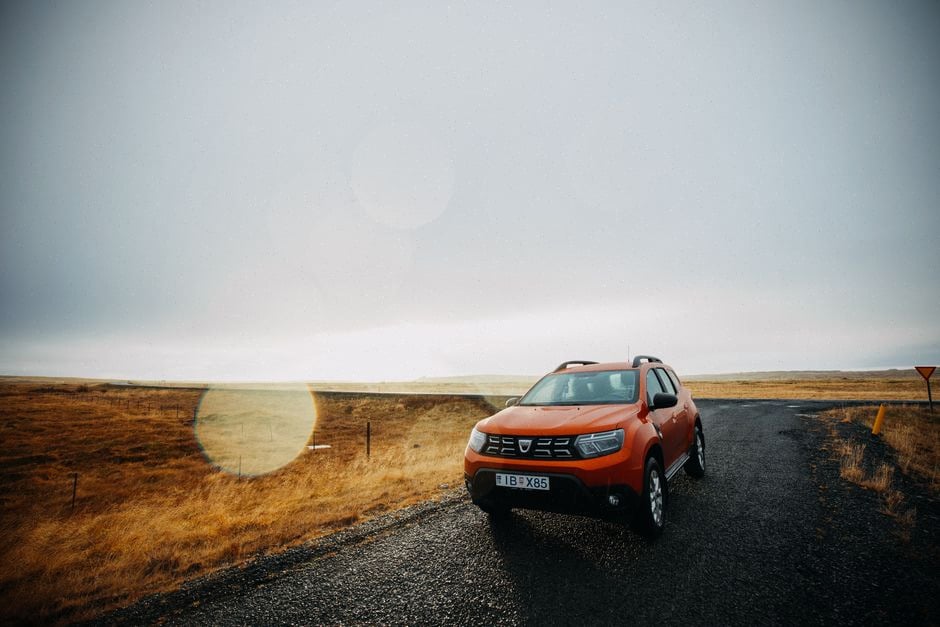 SUV 4x4 familial Dacia sur route rurale humide