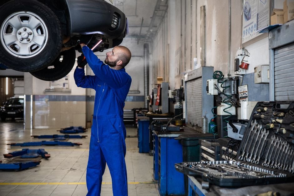 Technicien inspectant une voiture électrique dans une usine française moderne